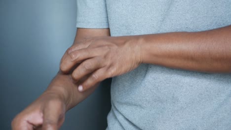 persona rascándose el brazo con picazón