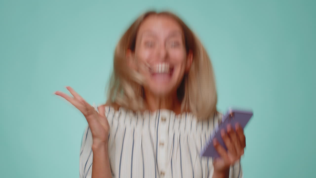 mujer feliz y emocionada usa el teléfono móvil y dice wow, sí, descubrí una gran noticia sobre una gran victoria haciendo un gesto de ganador