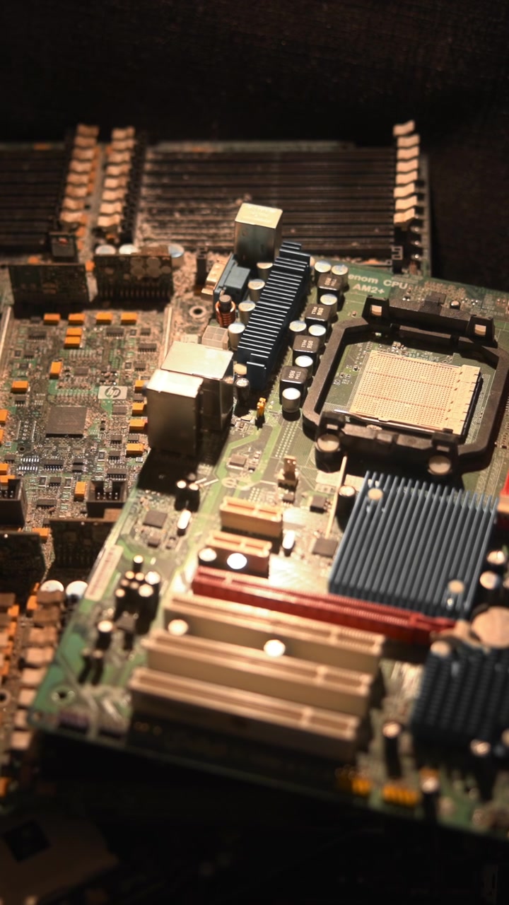 Nærbillede af bundkort på mørkt stof, der viser sokkel, køleplade og RAM-slots under spotlys. Fotografens rolle. Medie.
