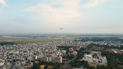 aerial drone shot of a flight taking off from igi airport, delhi, soaring above the cityscape.