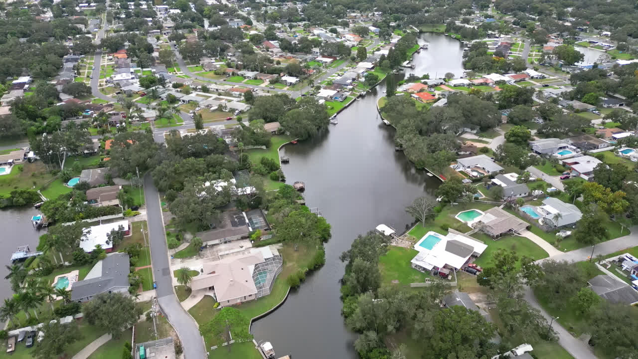 Aerial overview of community along canal waterways, panoramic establishing