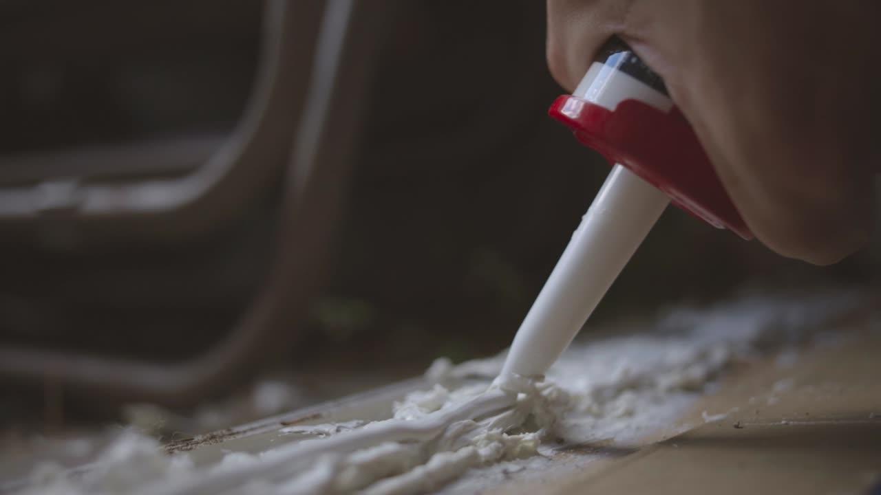 Applying Sealant To Surface Joint With A Caulking Gun - close up