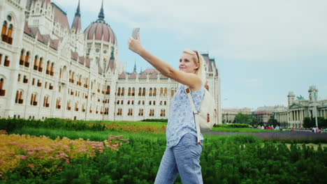 Mujer-Joven-Se-Fotografía-A-Sí-Misma-Con-El-Telón-De-Fondo-Del-Parlamento-Húngaro-En-Budapest-1