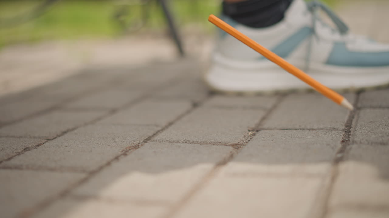Urban environment with active details. Capturing daily urban moments with footwear and writing instruments. Detailed portrayal of city sidewalk life emphasizing movement footwear and everyday objects