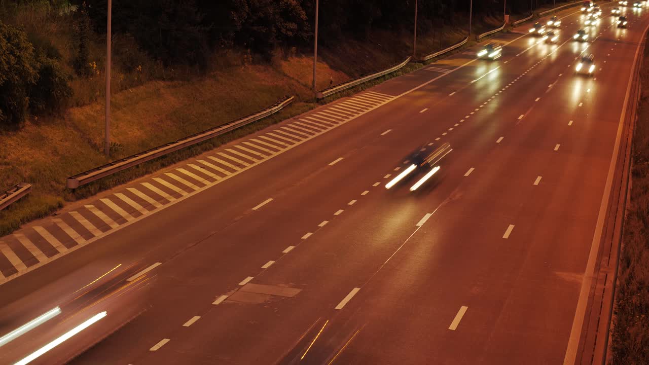 A cinematic timelapse of a highway at night with moving car headlights and subtle anamorphic flares