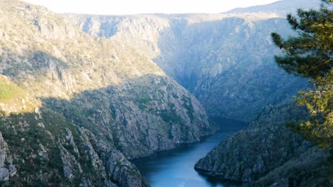 리오 실 강 (rio sil) 은 리베이라 사크라 협곡 (ribeira sacra canyon) 을 가로질러 흐르고 있으며, 태양빛이 산의 상단 벽에 떨어지면서 흐른다.