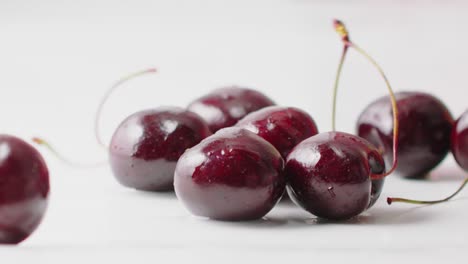 las cerezas rojas húmedas cayendo
