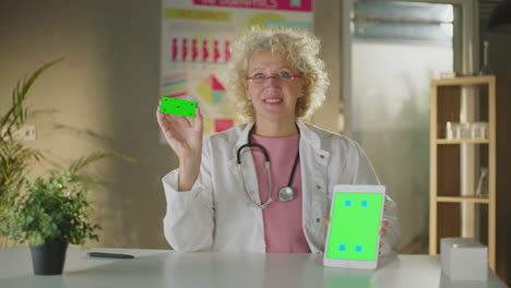doctor presenting with green screen tablet and card