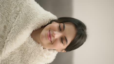 retrato de una joven hermosa mujer en una cálida manta en casa
