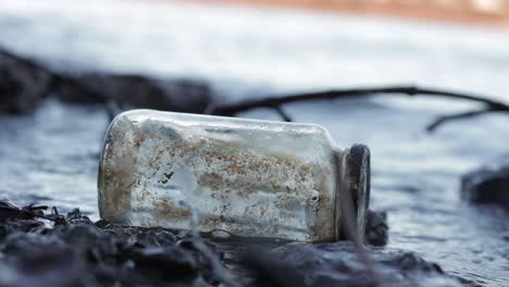 wasteful garbage floats in water. close up dirty glass jar littering environment
