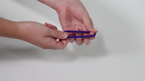 dos manos tirando de una corbata de cabello púrpura