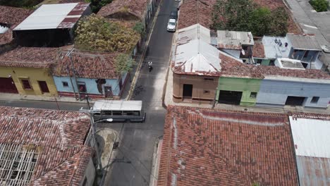 Rotating-aerial:-Bus-and-motos-in-narrow-San-Salvador-city-streets