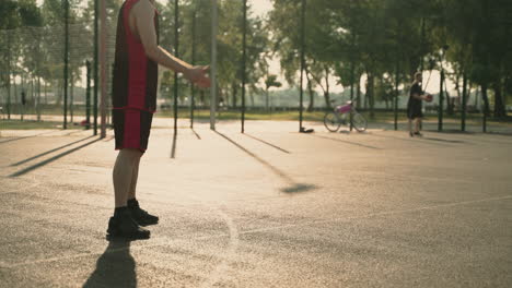 Skillfull-Male-Basketball-Player-Dribbling-Ball-Against-Opposing-Defender-And-Throwing-Ball-Into-Hoop