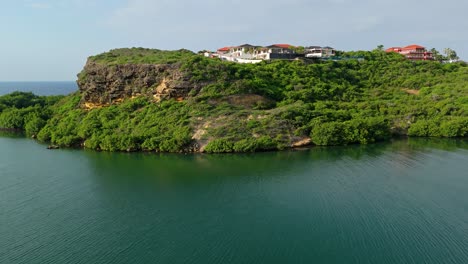 Drone-ascend-at-corner-of-Vista-Royal-neighborhood-Curacao-above-Caribbean-cliffs