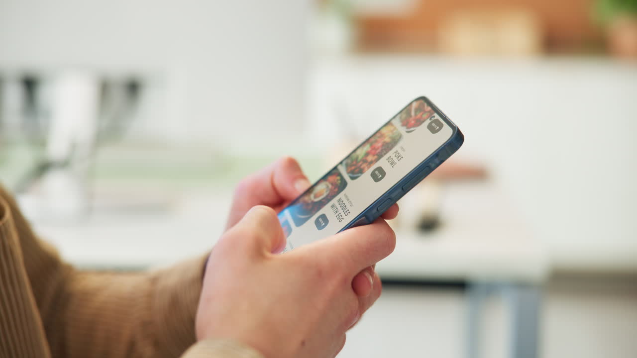 Close Up of Hands Scrolling Through Food Delivery App on Smartphone