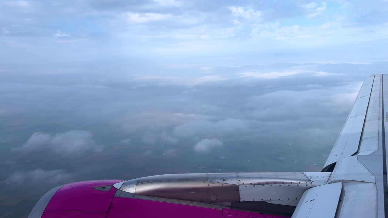 View from a plane window showcasing clouds under a bright blue sky
