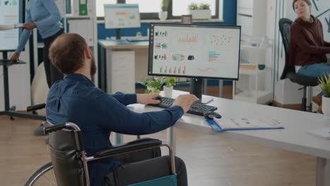 paralyzed business man writing financial report talking with colleague