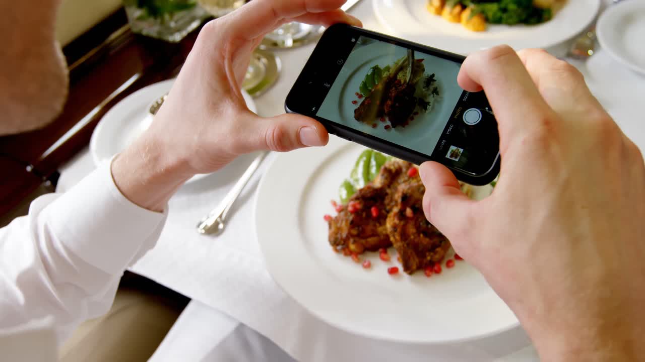 hombre de negocios tomando una foto de la comida con un teléfono móvil 4k