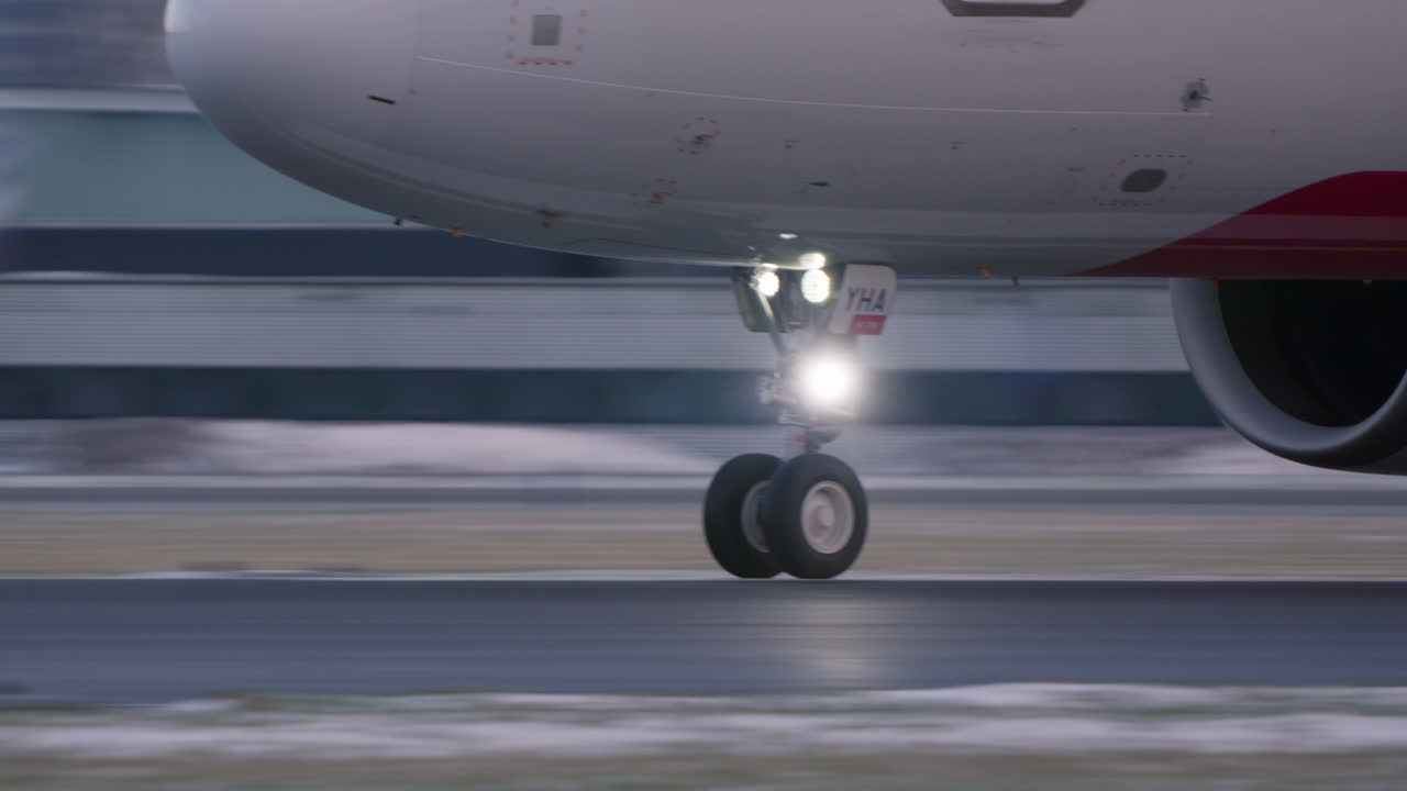 Carrello anteriore di un aereo commerciale in movimento sulla pista dell'aeroporto