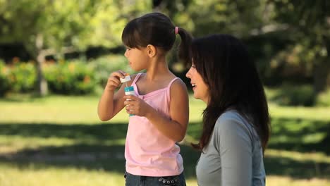 Girl-and-mother-blowing-bubbles