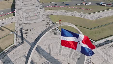 Bandera-Nacional-De-La-República-Dominicana-Ondeando-Con-El-Viento-En-El-Arco-Triunfal-En-La-Plaza-De-La-Bandera-De-Santo-Domingo,-República-Dominicana