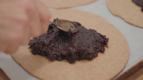 spreading plum filling on galette dessert, making pastry