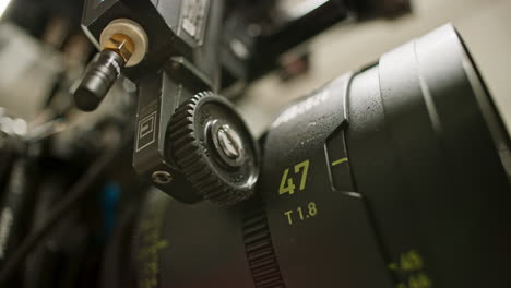 Low-angle-close-up-of-a-focus-motor-on-a-professional-cinema-camera-calibrating,-turning-the-focus-ring-of-a-high-end-spherical-prime-lens