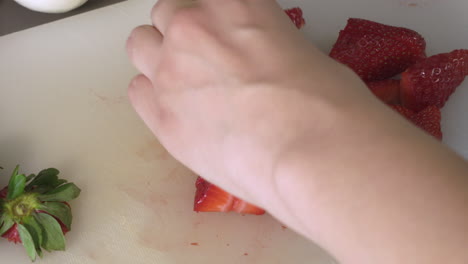 cutting a delicious and fresh red strawberries on a chopping board. - close up shot
