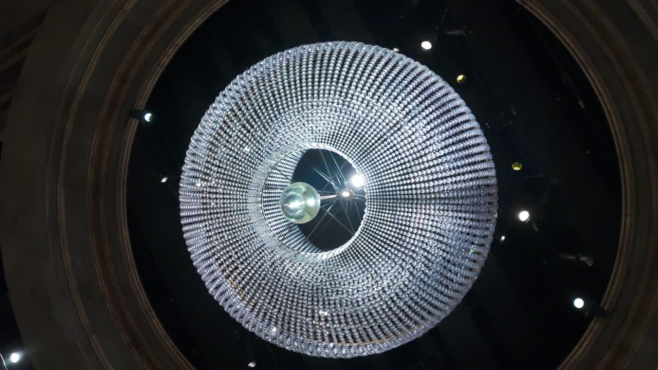 A huge, round, crystal chandelier. Spinning shot from beneath.