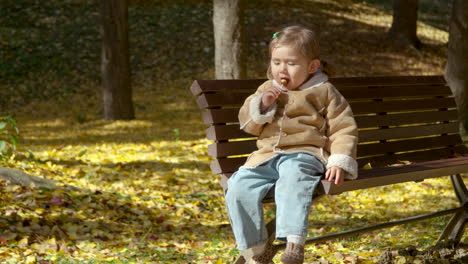 Young-Korean-Ukrainian-girl-on-bench-smiling-with-lollipop