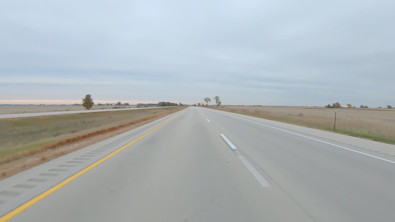 시골 서부 일리노이의 흐린 겨울날 평평하고 수확된 들판을 지나 주간 고속도로에서 pov 운전