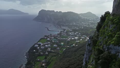 vista costera de capri, italia con exuberante vegetación y una carretera serpenteante, cielo nublado, con vistas al mar tirreno