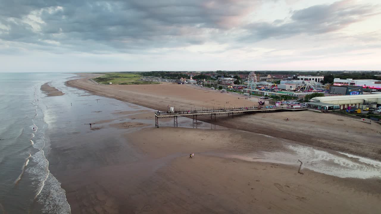 Sunset paints a stunning backdrop for Skegness pier in this aerial footage, capturing people as they walk along the pier's wooden structure