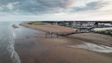 la puesta de sol pinta un impresionante telón de fondo para el muelle de skegness en esta imagen aérea, capturando a la gente mientras caminan a lo largo de la estructura de madera del muelle