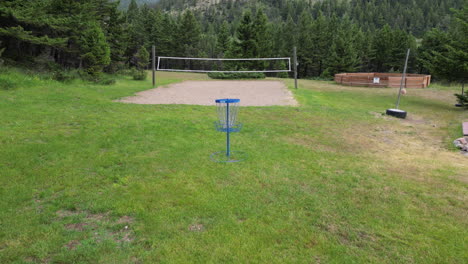 summer campground clearing with volleyball, basketball, and disc golf