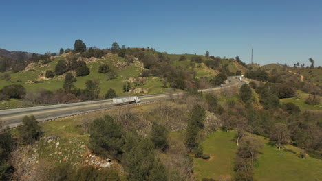 las lluvias de primavera traen hierba verde a las estribaciones de tehachapi - vista aérea del tráfico de carreteras