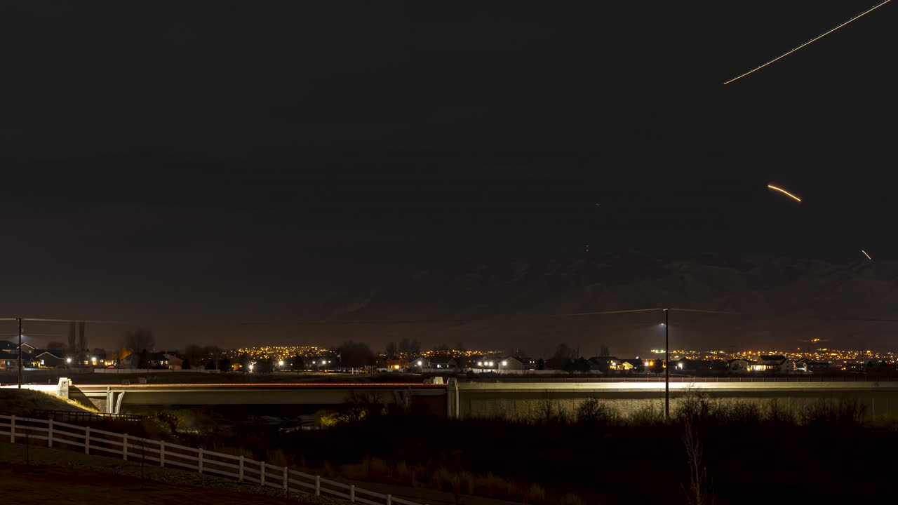 Sunset to dark night with a highway and emergency response crew, mountains and lots of airplane light trails - long exposure time lapse
