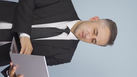 Vertical-video-of-Businessman-looking-at-laptop-getting-frustrated.-Sad-and-helpless.