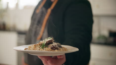 chef serving mushroom risotto