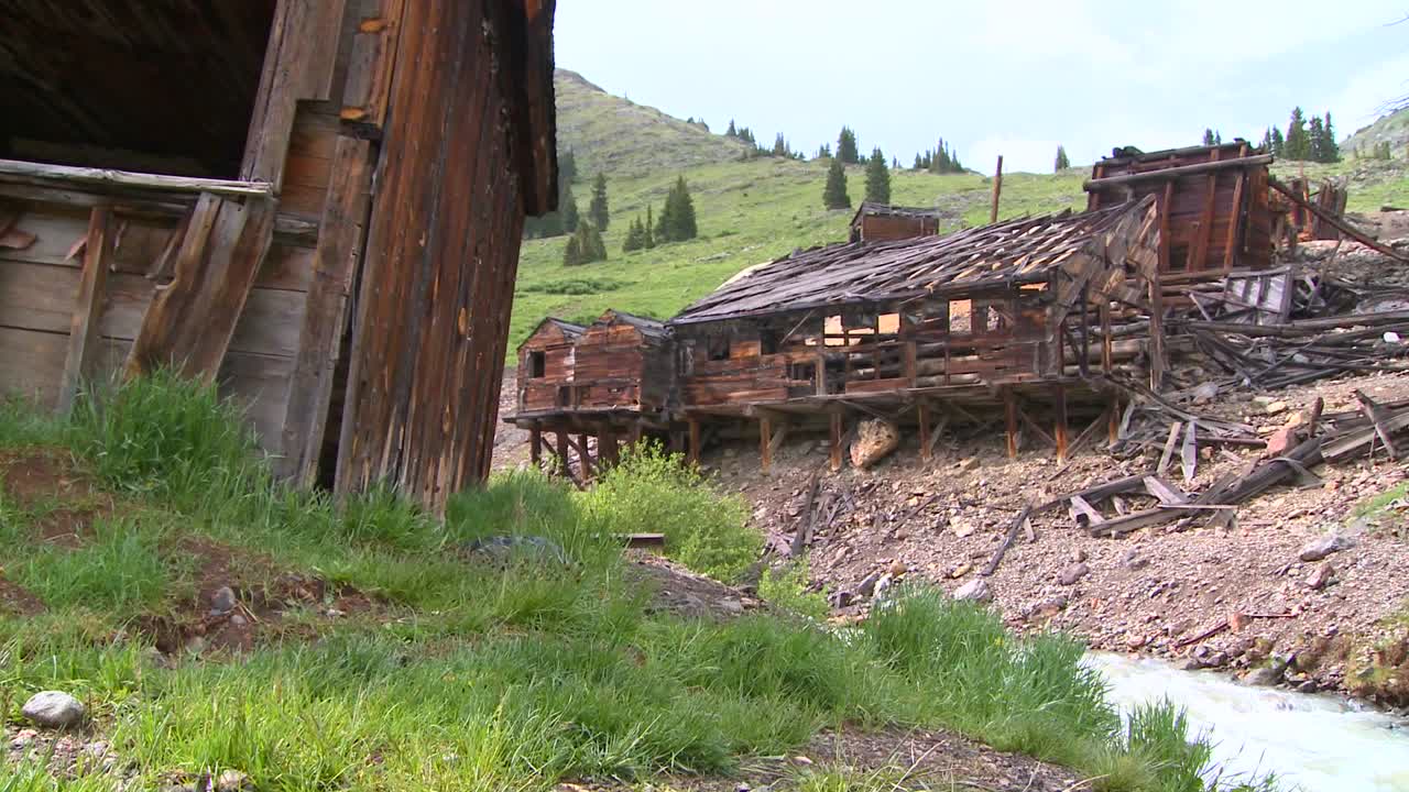 un travelling se mueve a lo largo de un pueblo fantasma y un río