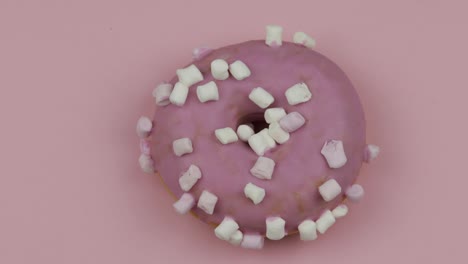 sweet donut rotating on pink background. top view. tasty, fresh donut