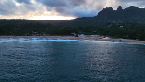 drone panning in front of the anahola beach, cloudy sunset in kauai, hawaii