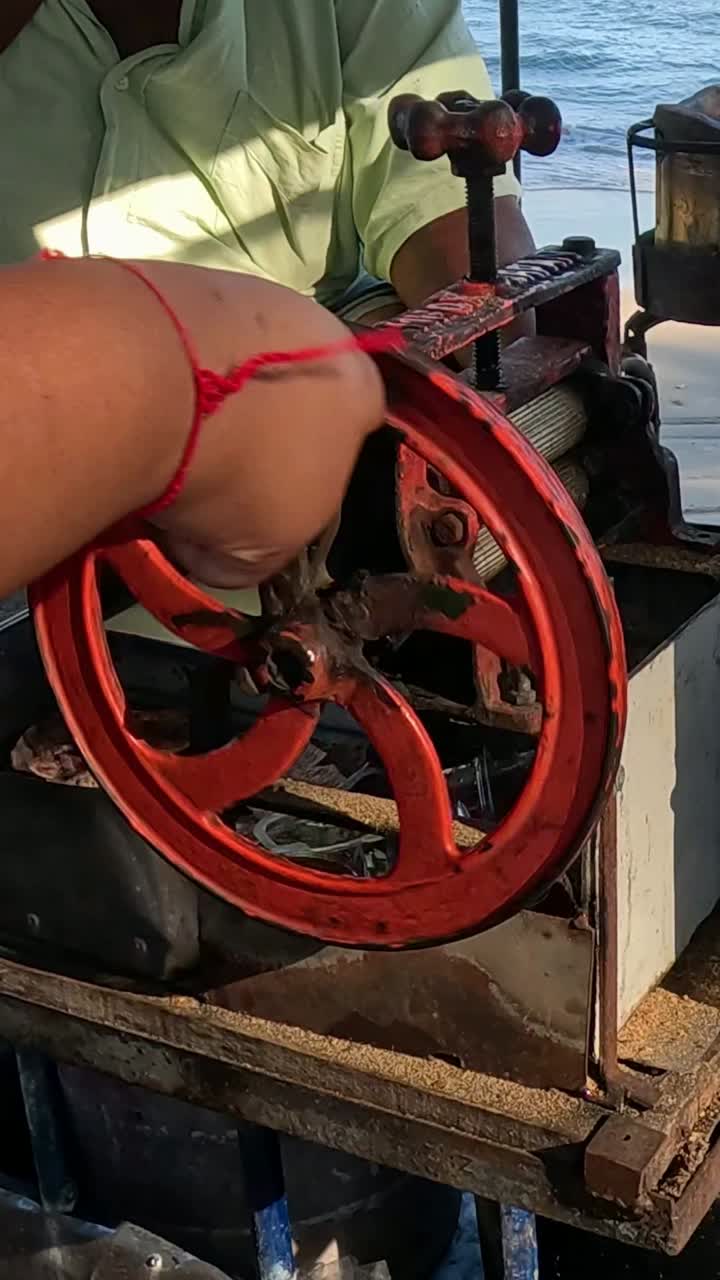 persona que opera un carrete mecánico junto al océano