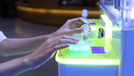 hands interacting with a glowing game cabinet