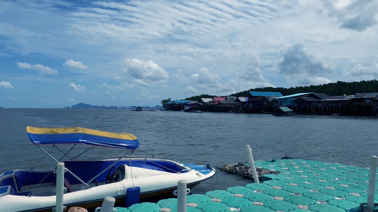 Speed boat at local village pier on cyan green sea n ocean water