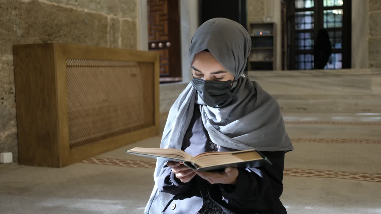 모스크 안에서 꾸란을 읽는 히자브를 입은 소녀