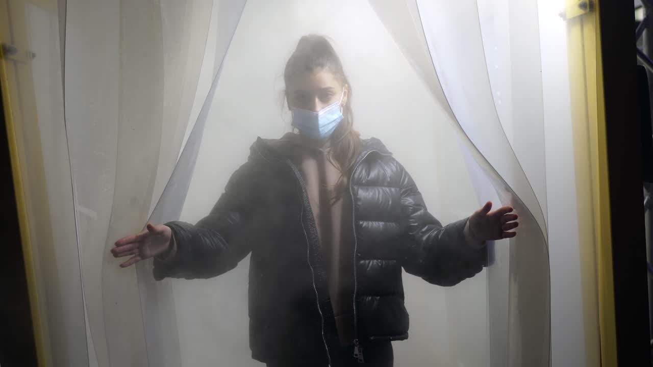 보호 장벽 뒤에 마스크를 착용 한 소녀