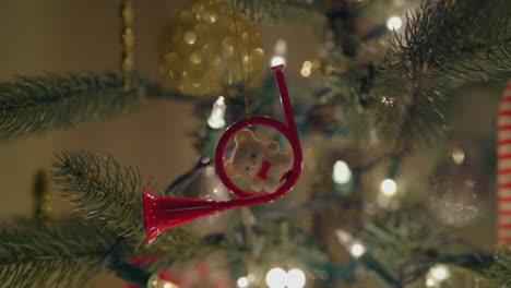 a closeup of a trumpet instrument ornament surrounded by holiday lights on a christmas tree