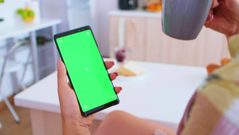 woman holding portable phone with green screen