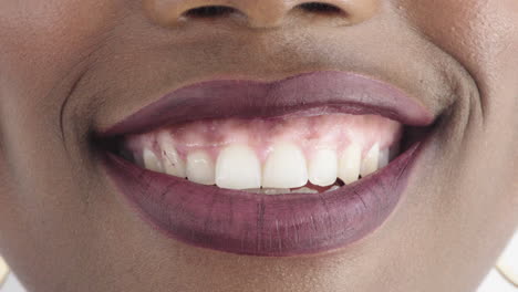 de cerca labios de mujer afroamericana sonriendo felices dientes sanos lápiz labial brillante maquillaje cosméticos belleza femenina